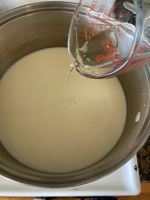 pouring the rennet in the milk